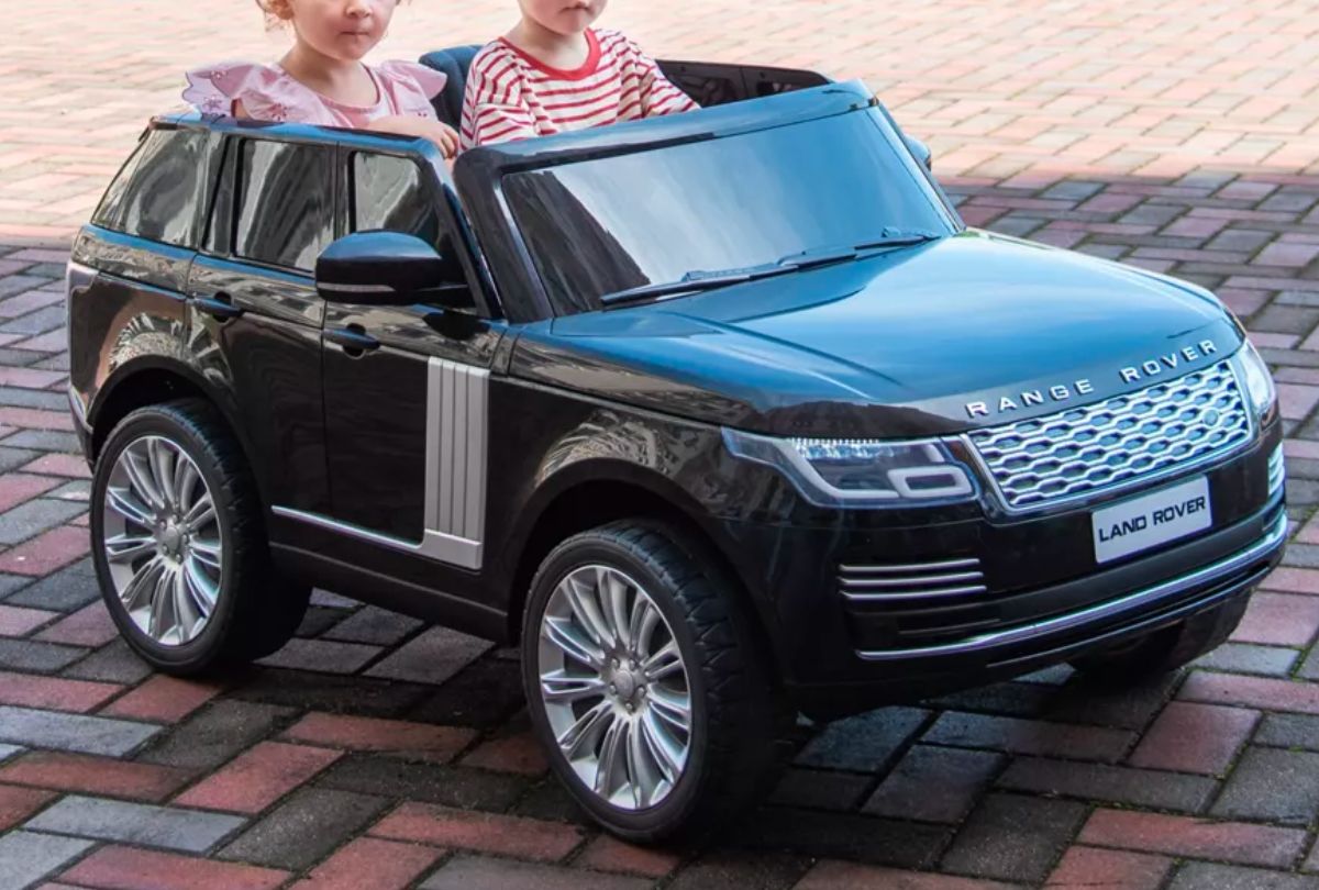 two kids in a black ride on range rover