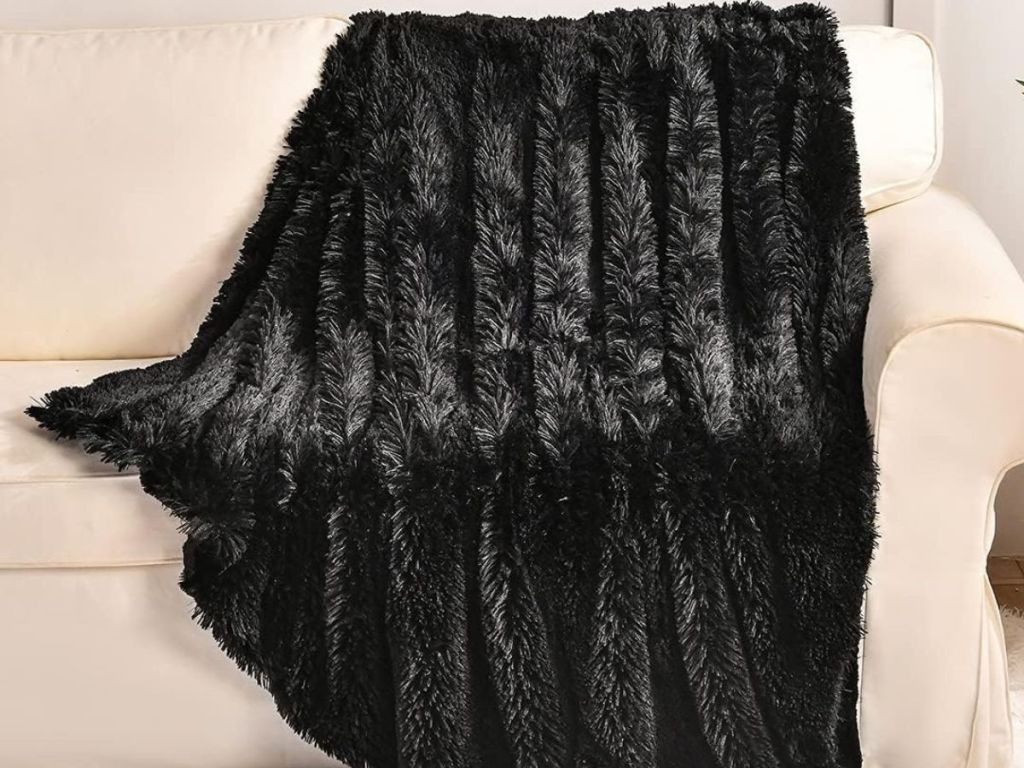 A black faux fur throw on a couch