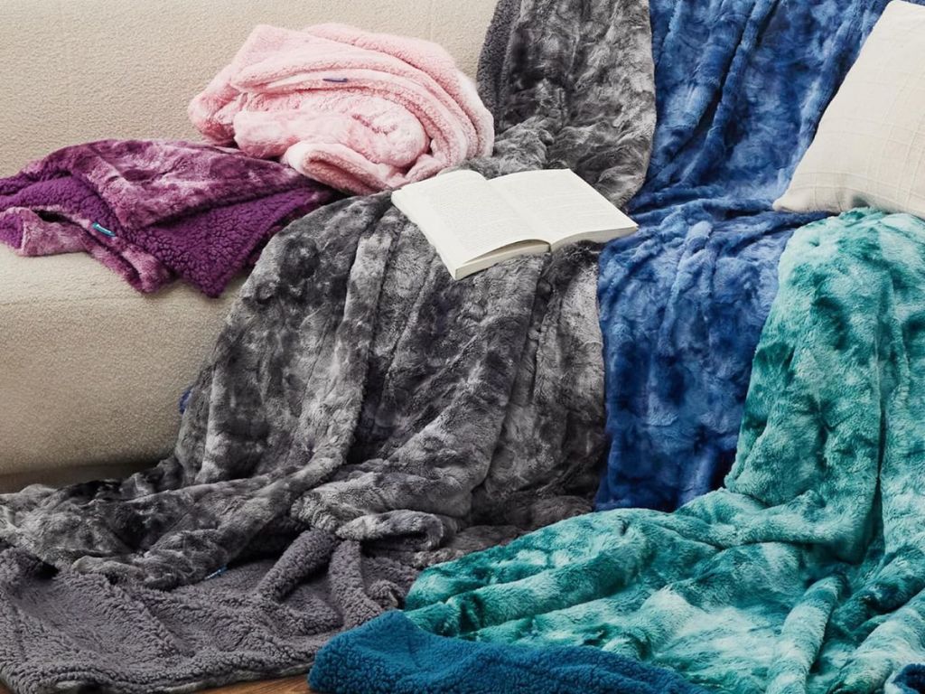Faux fur throw blankets in several colors on a couch