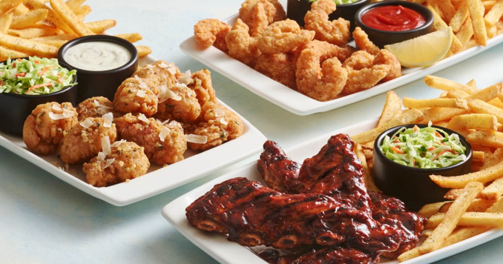 Plates of Applebee's, riblets, fried shrimp, and boneless wings with french fries, coleslaw and sauces