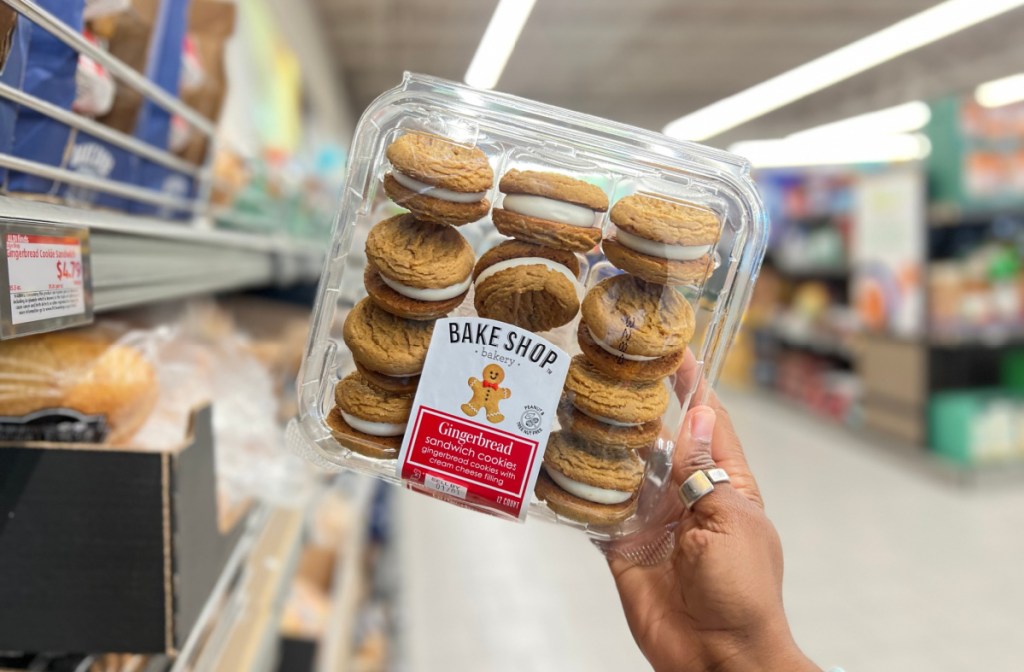 Hand holding up gingerbread sandwich cookies, seasonal baked goods from Aldi that are on our Aldi grocery finds list