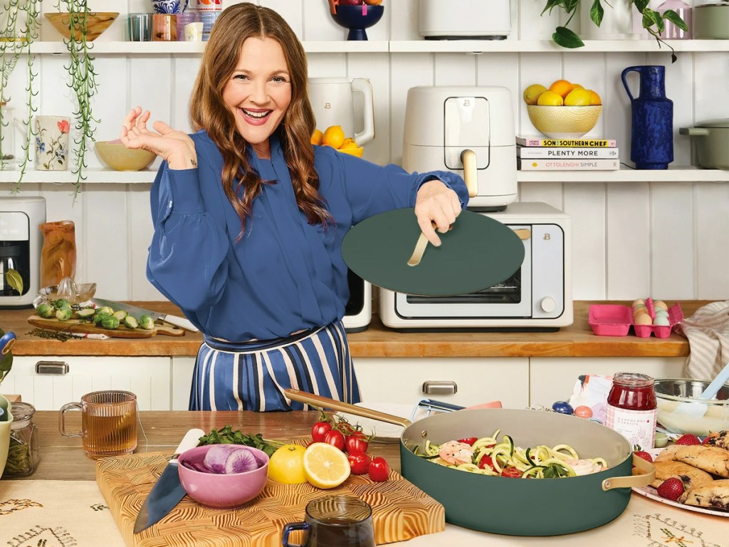 Drew Barrymore holding lid to green and gold frying pn