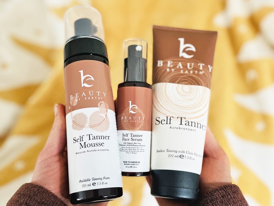 hands holding up 3 Beauty by Earth self tan products