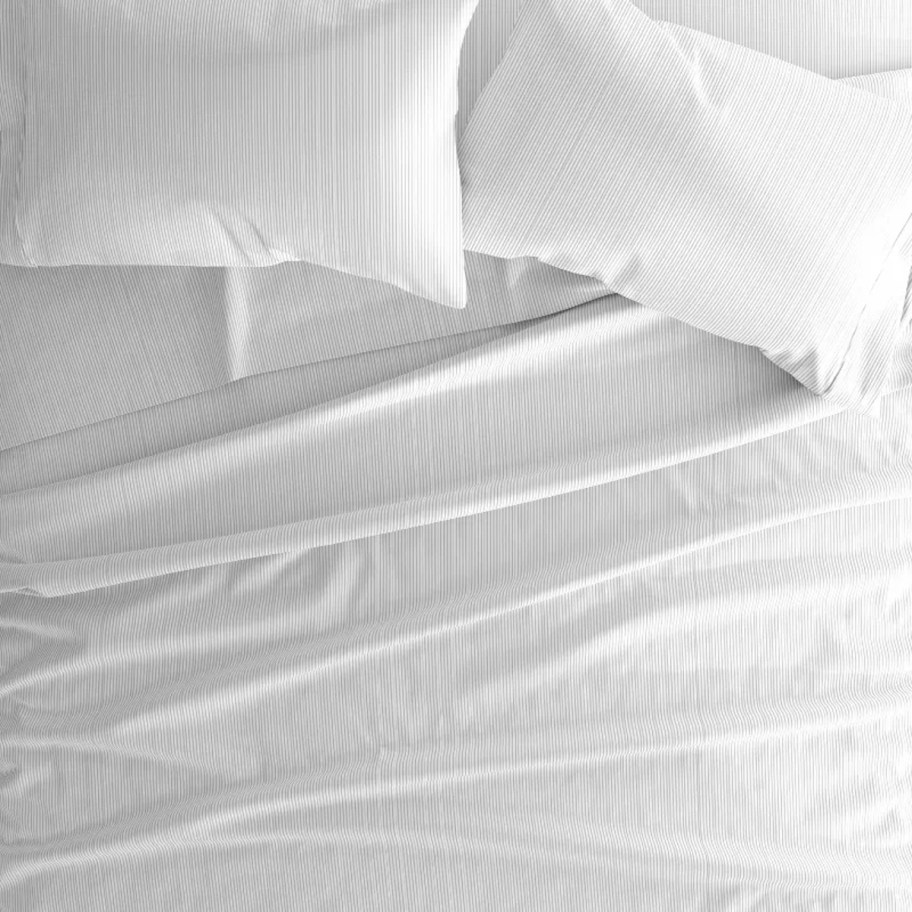 top view of bed with white striped sheets and pillows