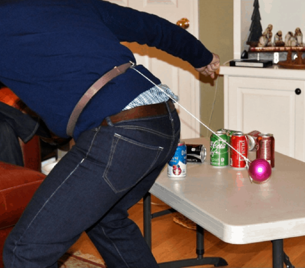 Man with ornament tied to his belt playing the Christmas party game Bottoms Up!