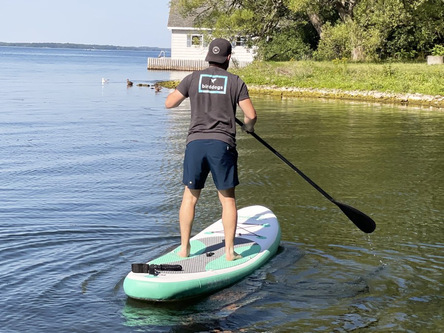 man standing on inflatable paddle board