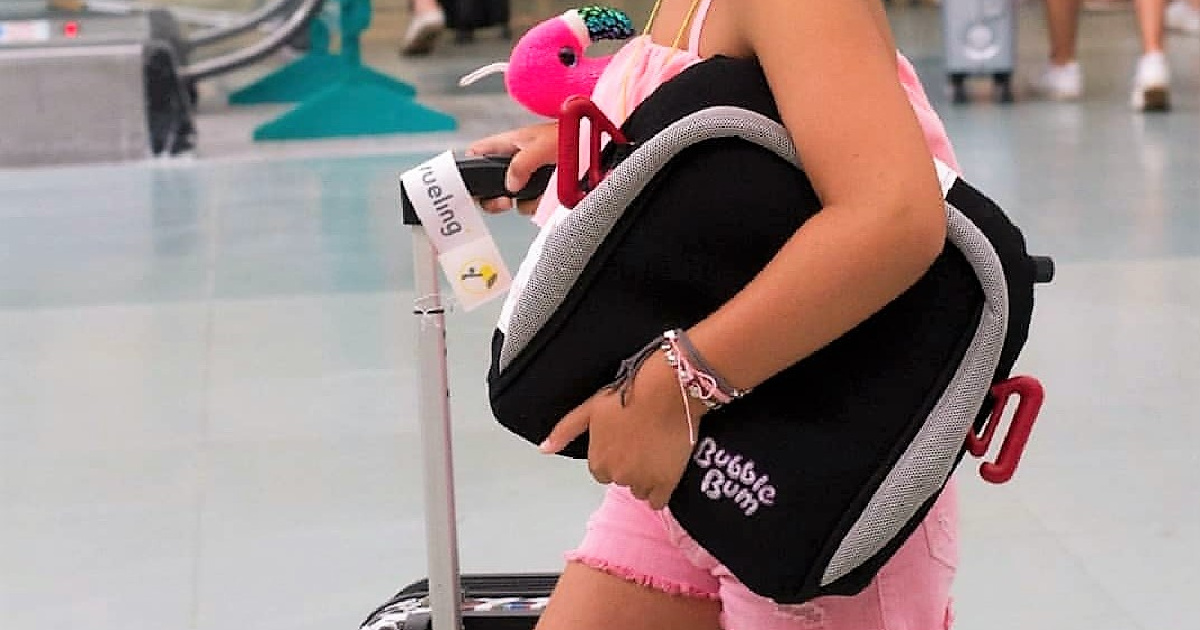Girl holding travel carseat