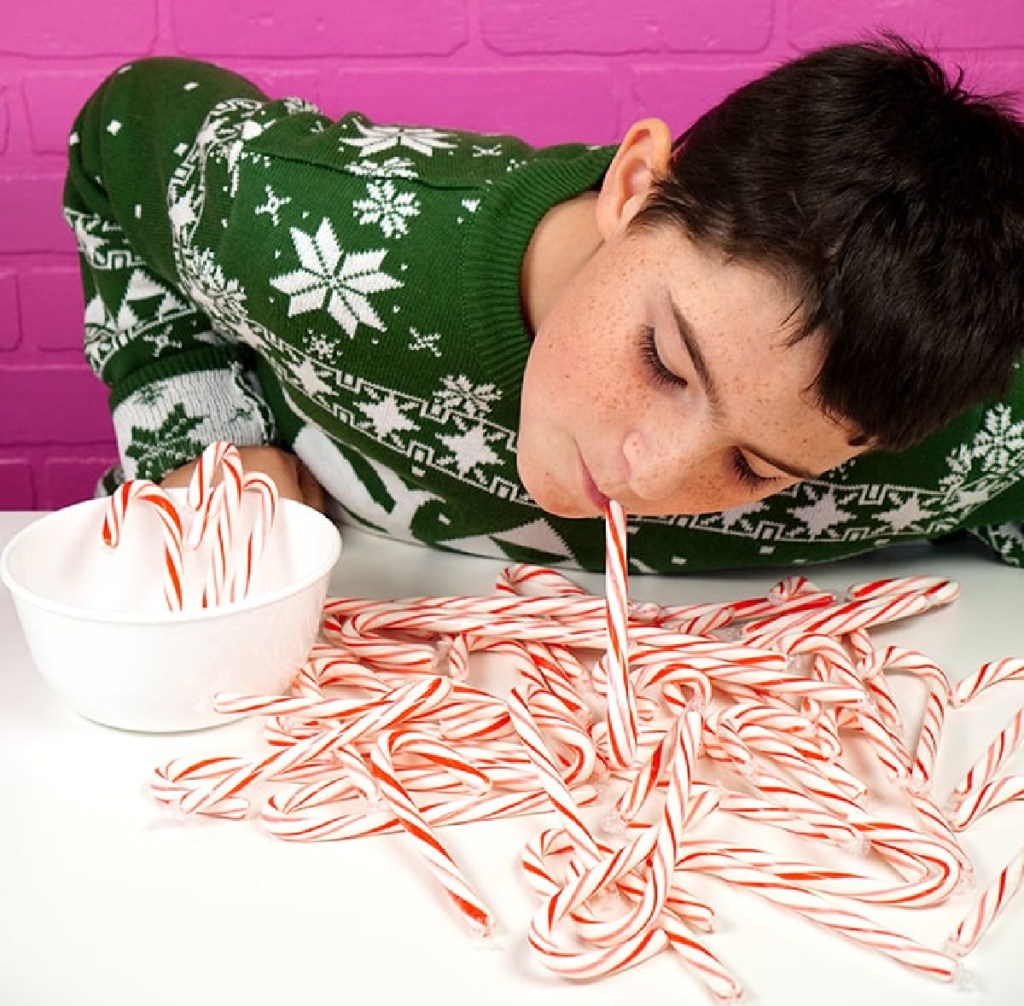 A boy playing Candy Cane Hook Em one of the Christmas games for kids and Christmas games for adults