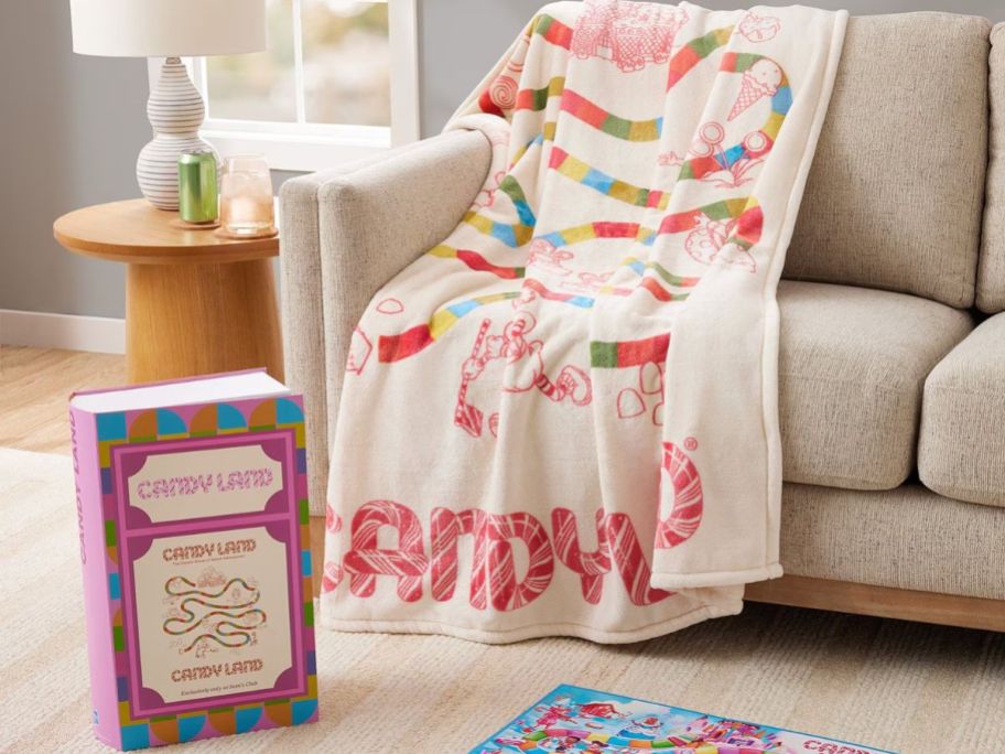 Candy land throw blanket on the couch with its box on the floor