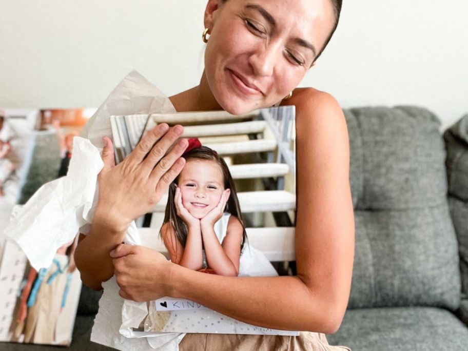 woman hugging a custom photo canvas print of her little girl