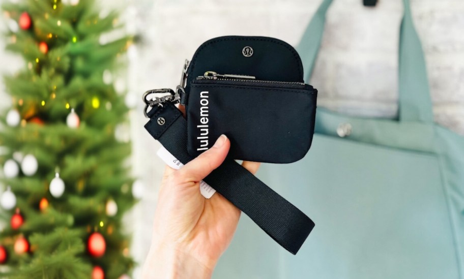 hand holding a black lululemon dual pouch wristlet