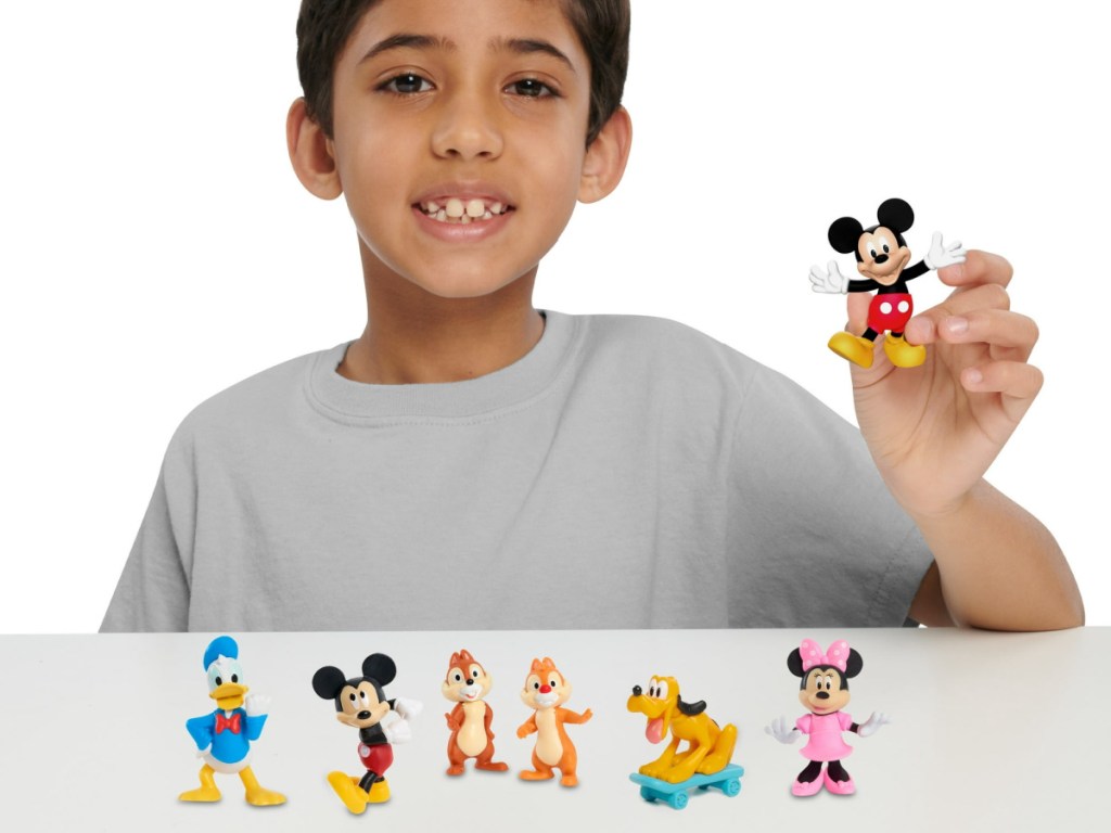 boy holding up Disney Collectible Figures
