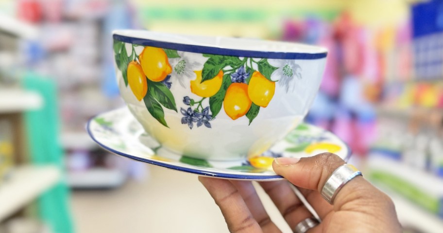 hand holding up lemon print bowl on top of matching salad plate