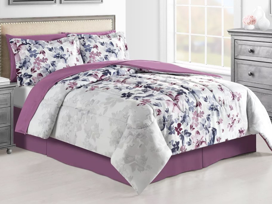 grey and purple floral print comforter set on bed with purple sheets