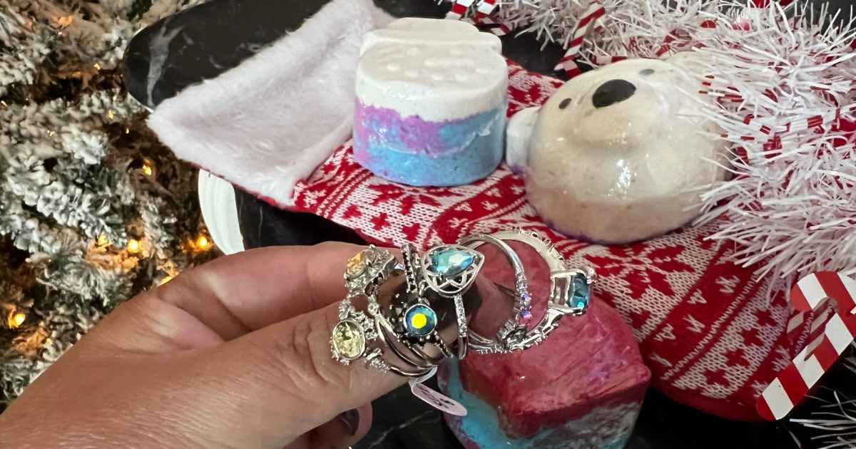 hand holding rings with bath bombs in background