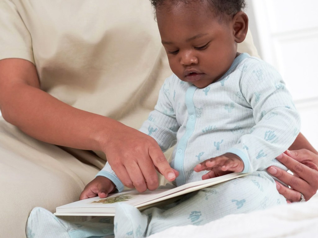 reading to baby in blue footed pajamas