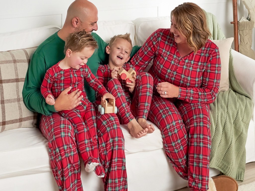 family on couch wearing matching red plaid pajamas