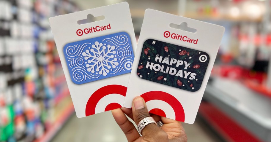 Gift Cards at Target being held by a person in the aisle