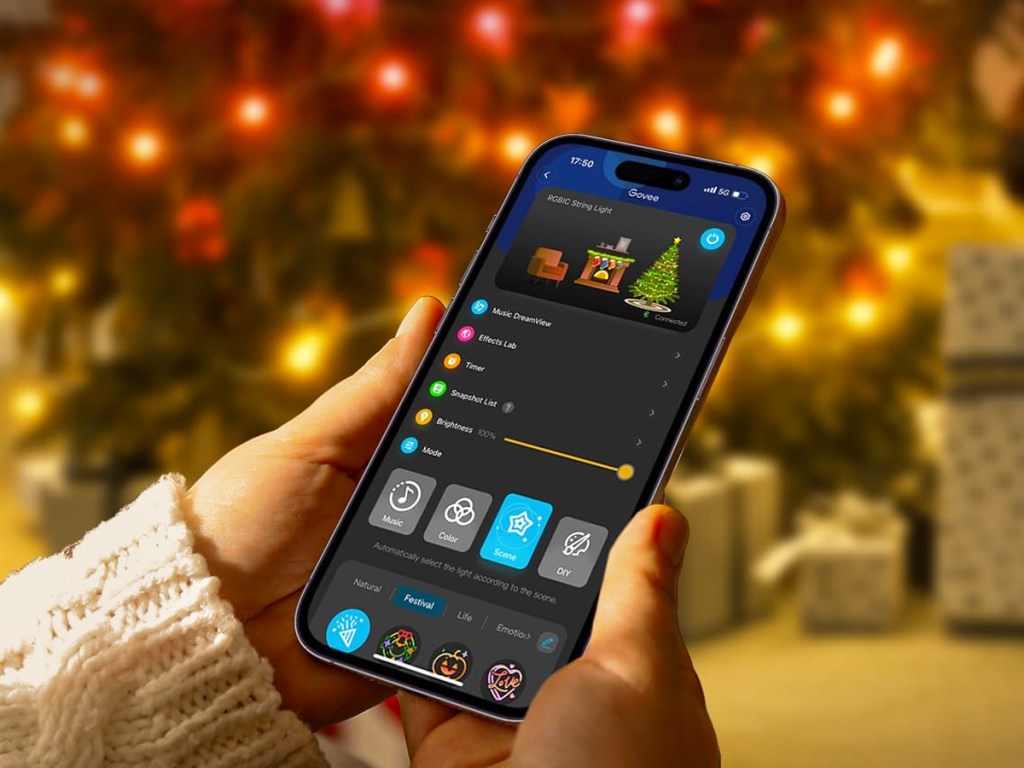holding a smartphone with controls for christmas lights
