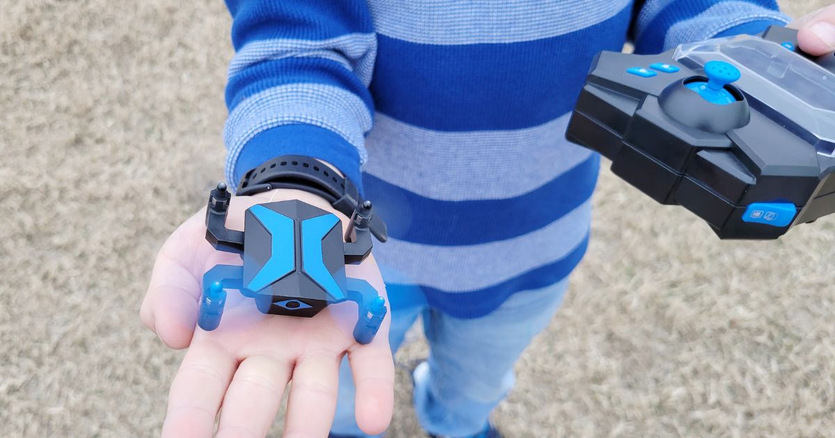 child's hand holding an ATTOP Mini Drone 