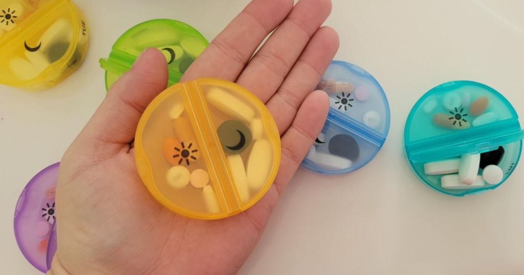 hand holding daily pill box from Sukous Weekly Pill Organizer with Morning & Night Sections & Case