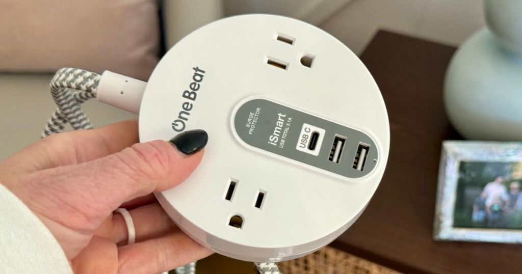 One Beat small round power strip in woman's hand