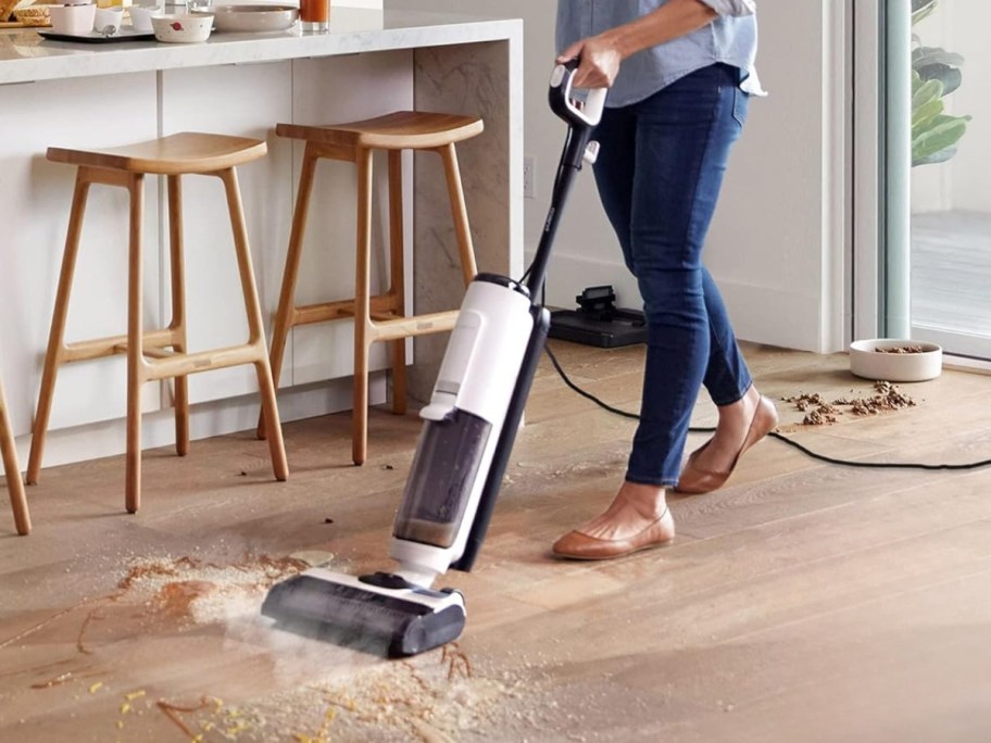 woman cleaning up a wood floor with a Tineco wet/dry vacuum