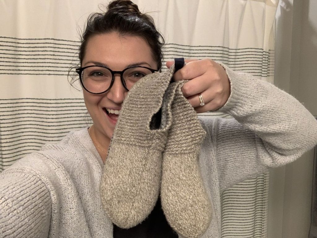 Alli holding up pair of Bombas Gripper Slippers
