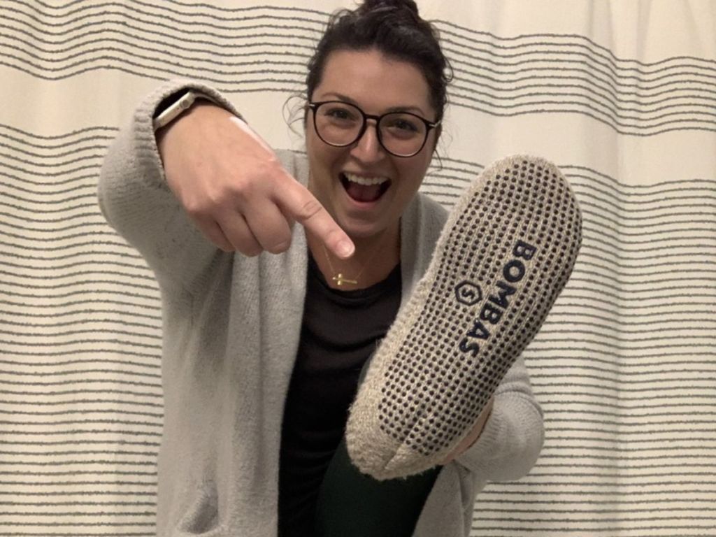 Alli pointing to a Bombas Gripper Slipper