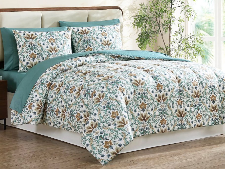 floral print comforter on bed with teal sheets