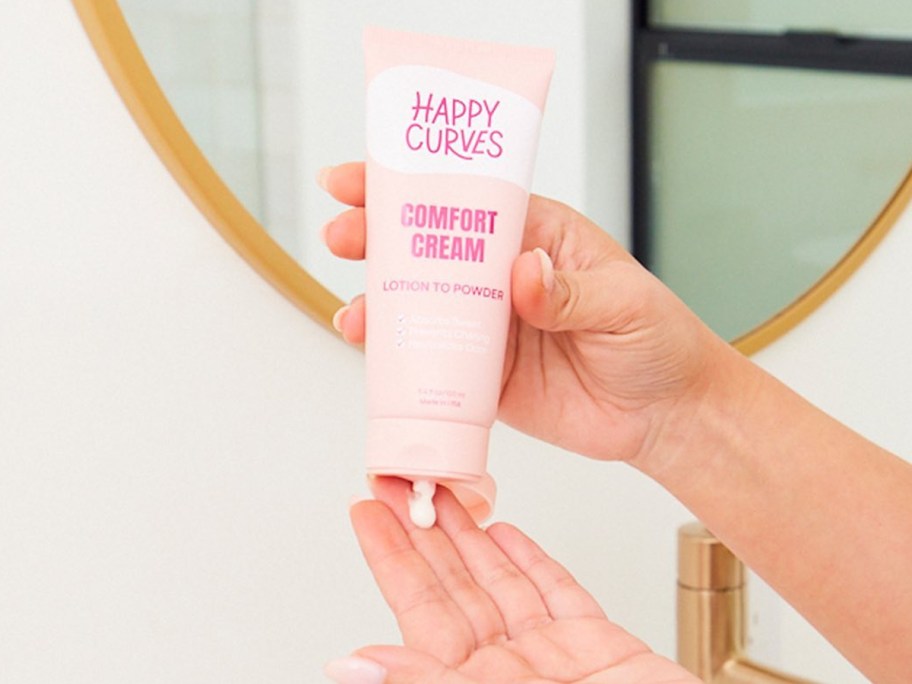 hands squeezing bottle of Happy Curves Comfort Cream