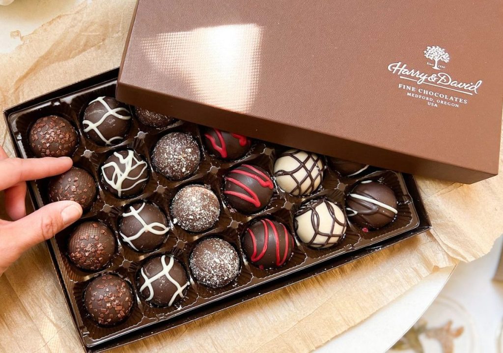 A box of Harry & David Truffles with a hand reaching for one