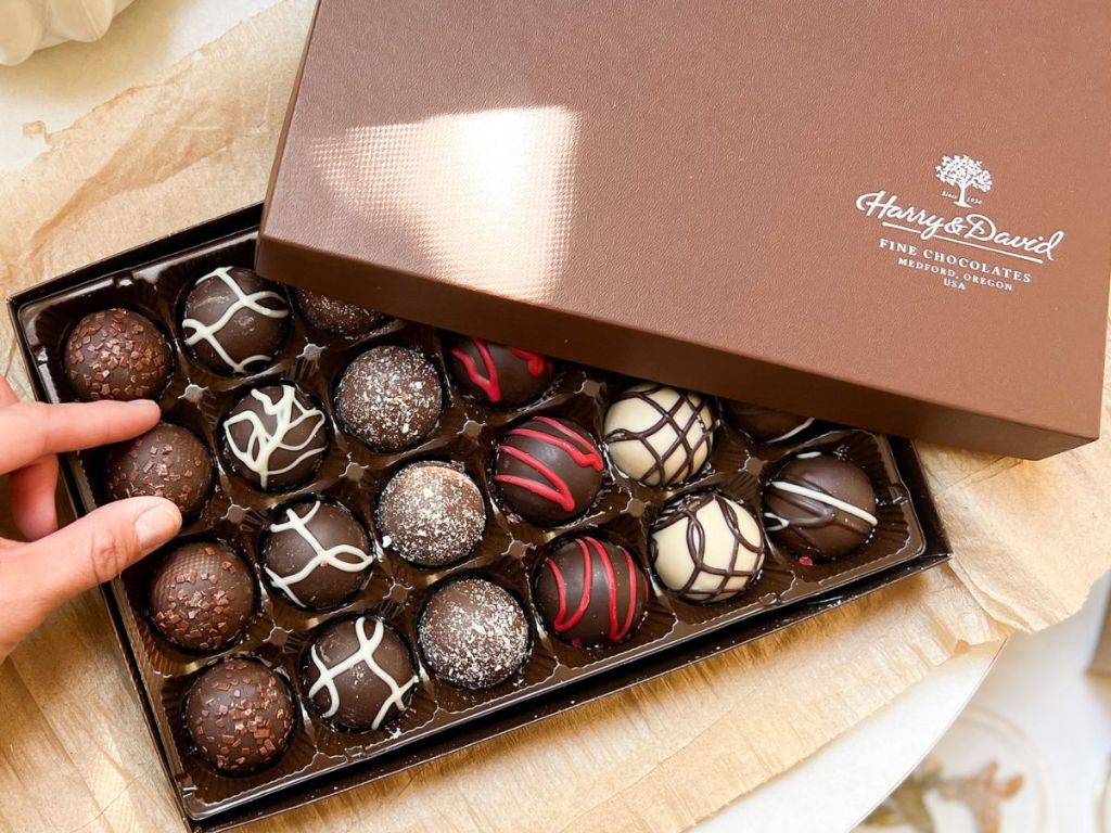 A box of Harry & David Truffles with a hand reaching for one