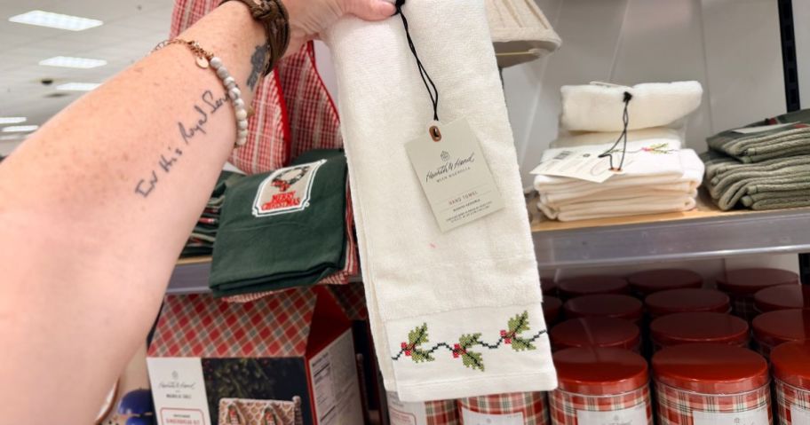 Hearth & Hand with Magnolia Christmas Holly Cross Stitch Hand Towel in hand in store