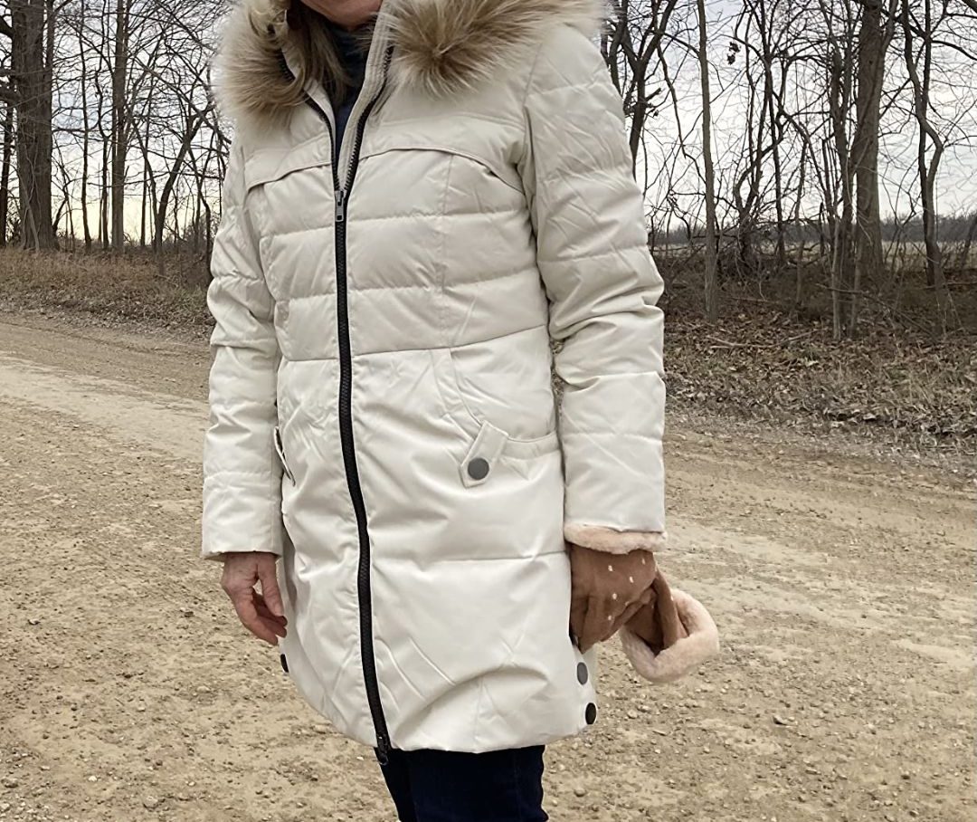 woman wearing a white Orolay Women's Winter Down Jacket with Faux Fur Trim Hood