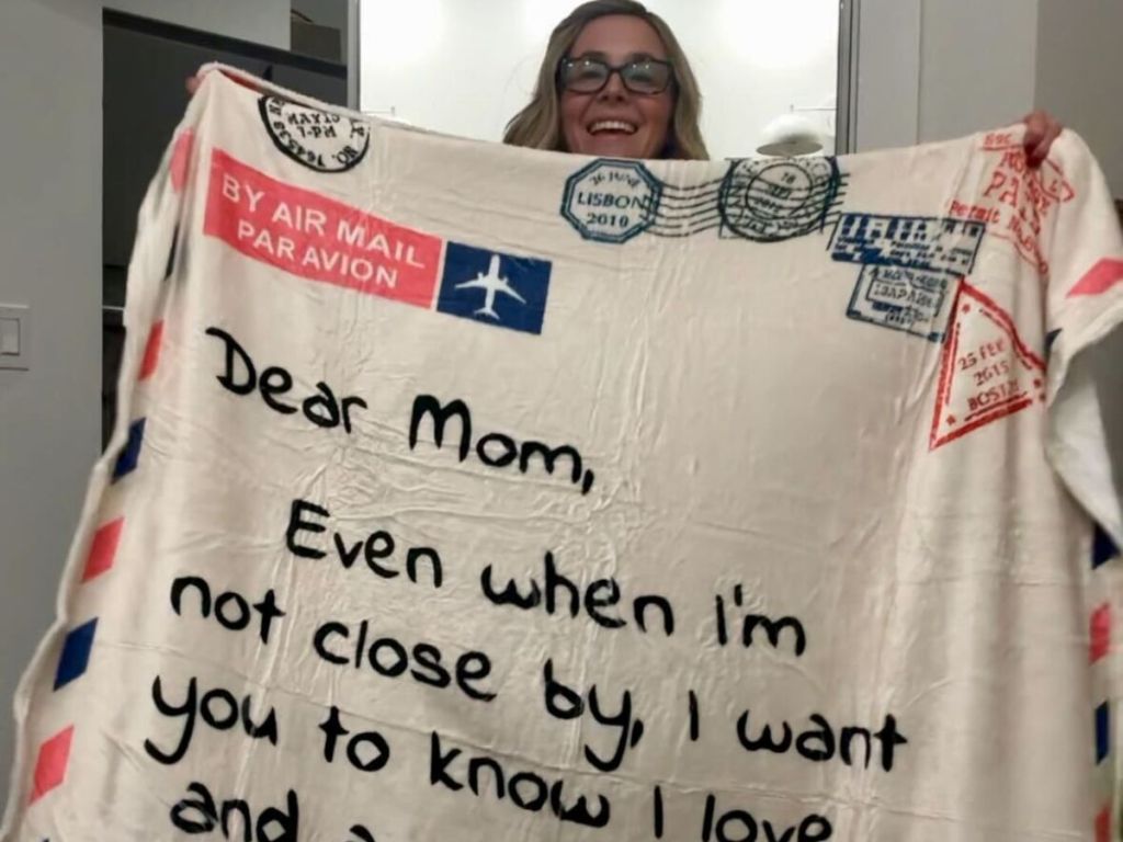 woman holding up Flannel Throw Blanket for Mom