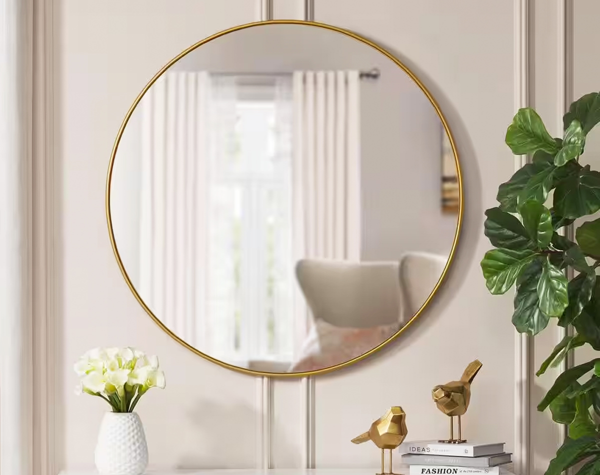 round gold framed mirror on wall