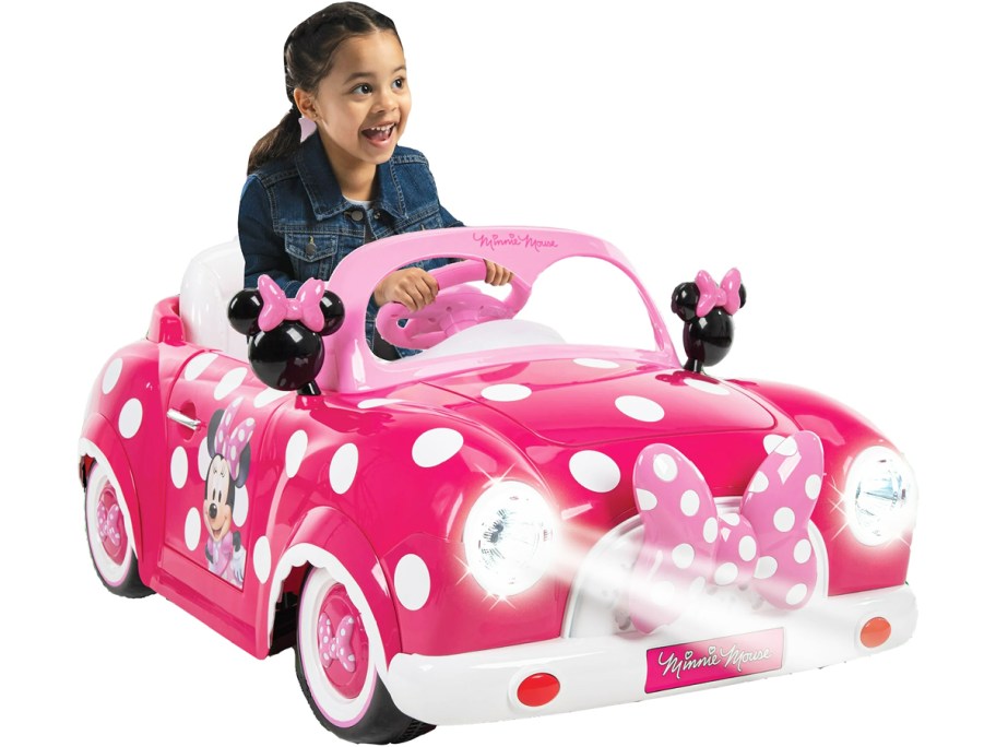 girl riding in a pink minnie mouse car