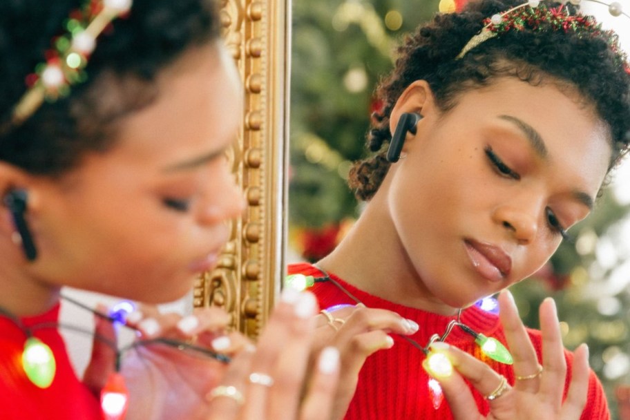 woman in christmas outfit wearing earbuds