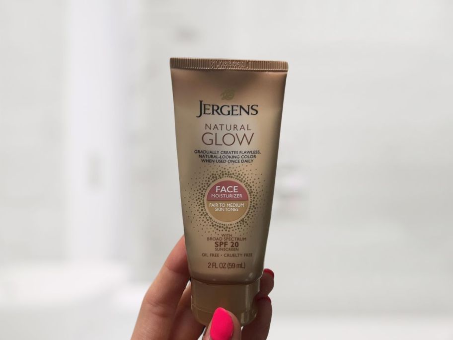 Jergens Natural Glow Face Self Tanner Body Glow Lotion 2oz in hand in bathroom