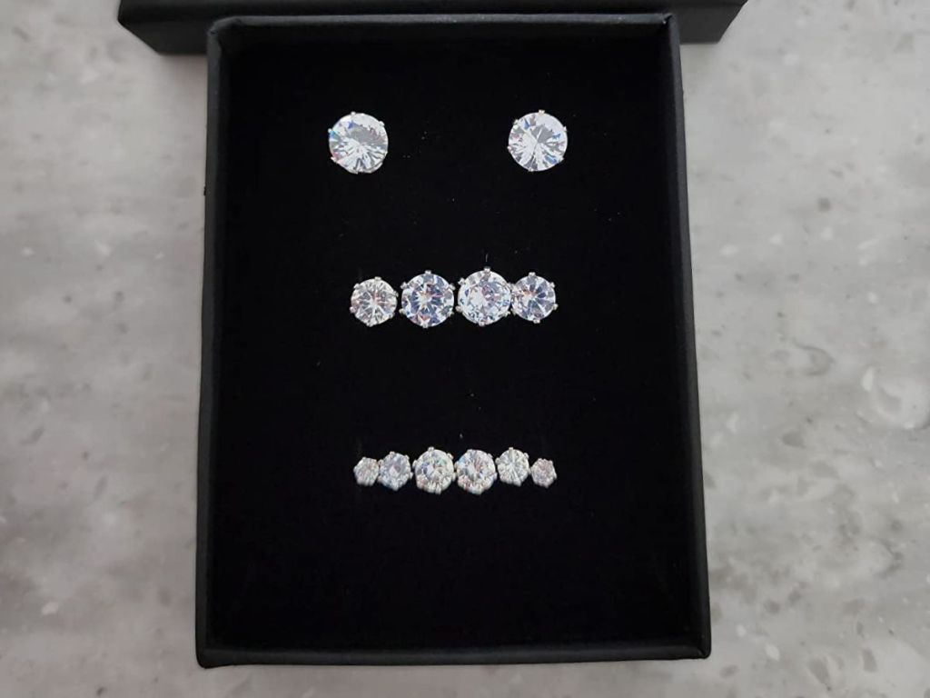 various pairs of stud earrings on velvet pad