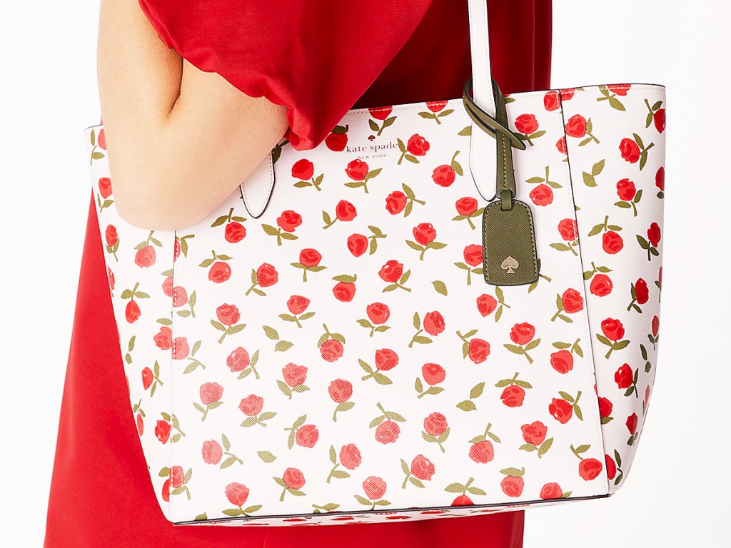 woman in red dress with floral print tote bag
