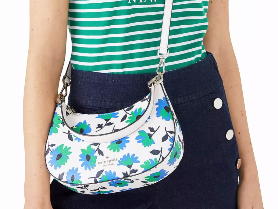 woman with white, blue, and green floral print crossbody bag