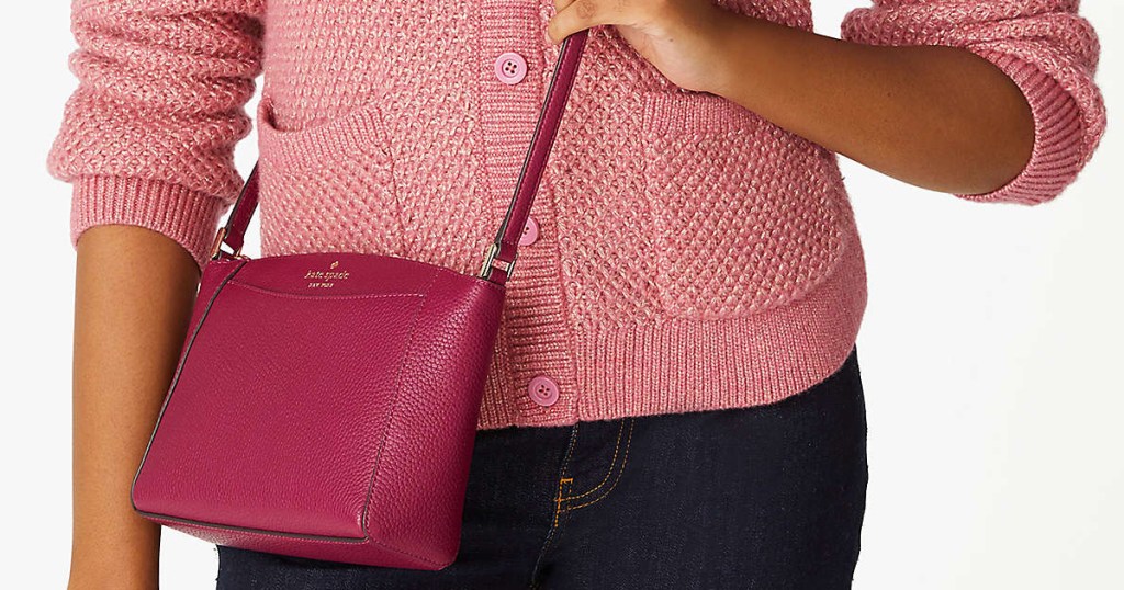 woman in pink sweater with red crossbody