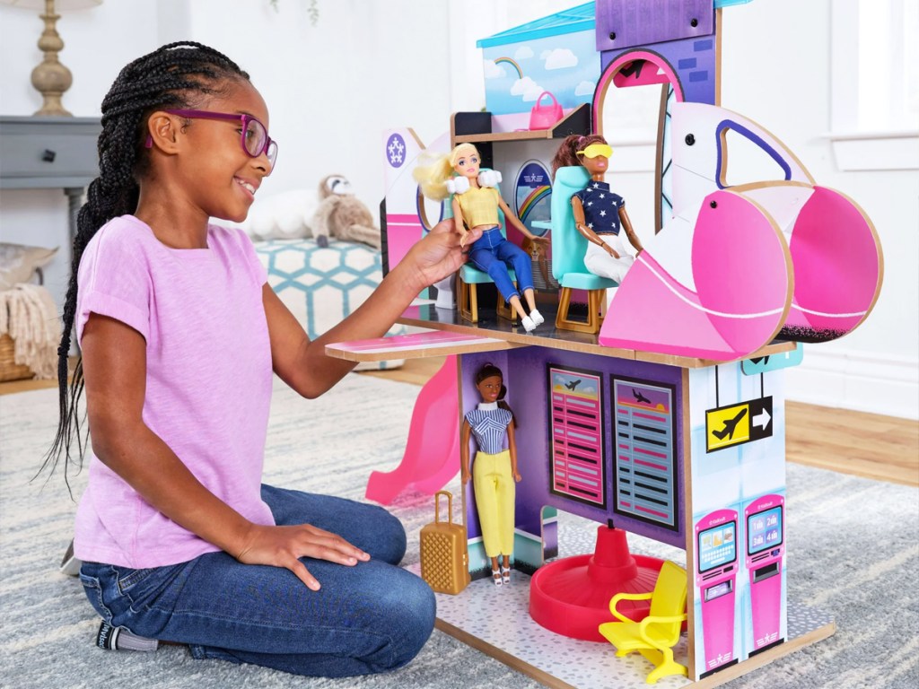girl playing with airplane themed dollhouse set