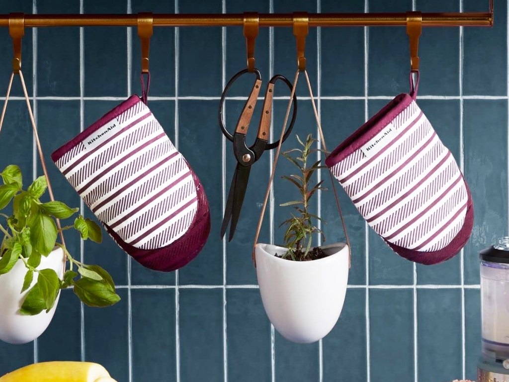 purple and white striped oven mitts hanging in kitchen