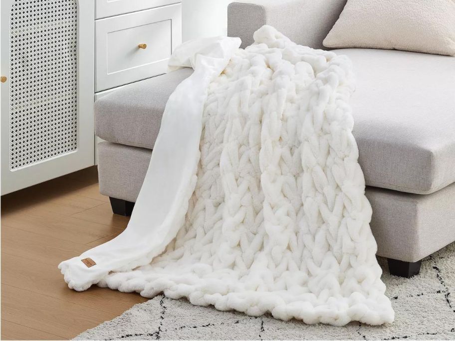 A comfy white blanket on a chaise lounge