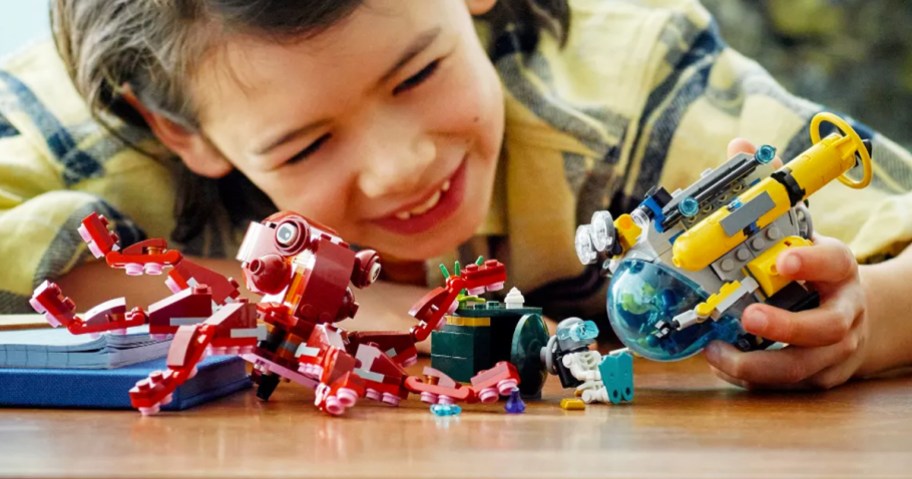 boy playing with LEGO Creator 3-in-1 Sunken Treasure Mission Octopus Set