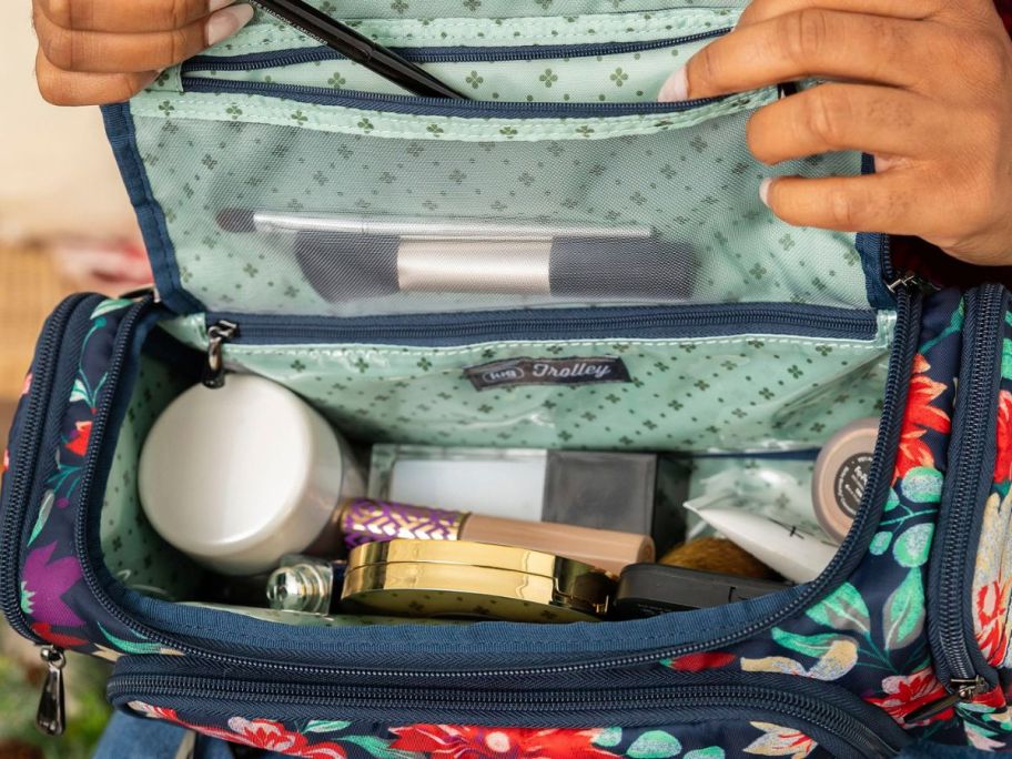 person putting makeup in cosmetic bag