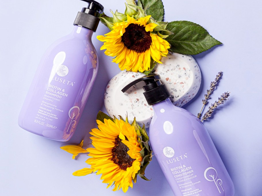 purple bottles of shampoo & conditioner next to sunflowers